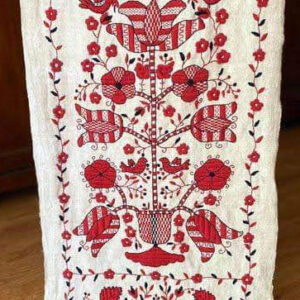 Біле полотно з вишитими червоними квітами