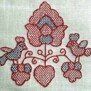 Вишиті червоними і синіми нитками квіти