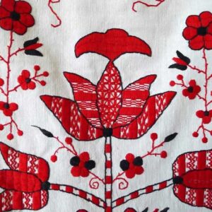 Біле полотно з вишитими червоними квітами